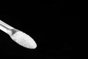 A glass container holds PVC powder