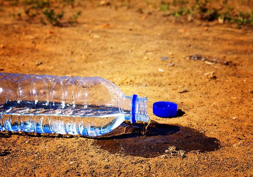 Water spilling from plastic bottle in sunlight